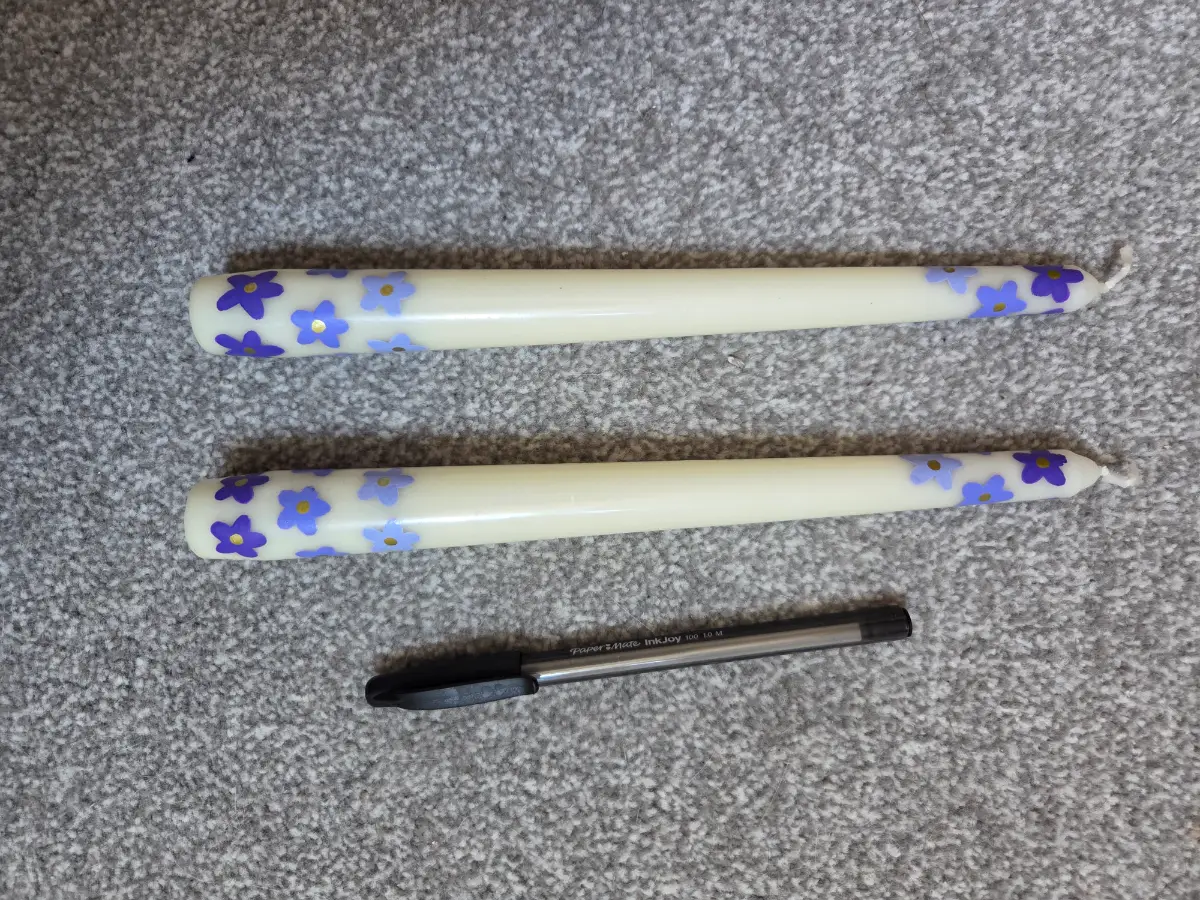 Cream taper candles with purple flowers