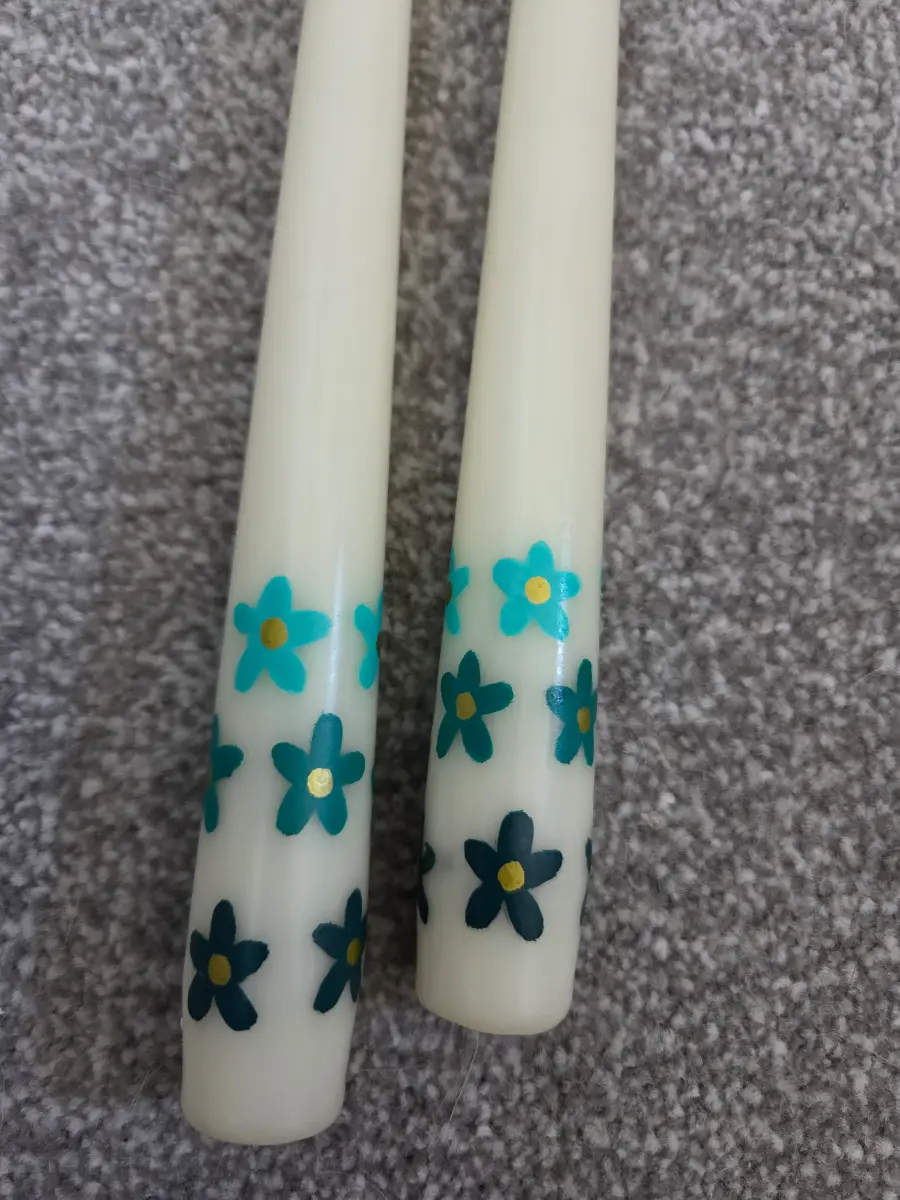 Cream taper candles with flowers in different shades of blue