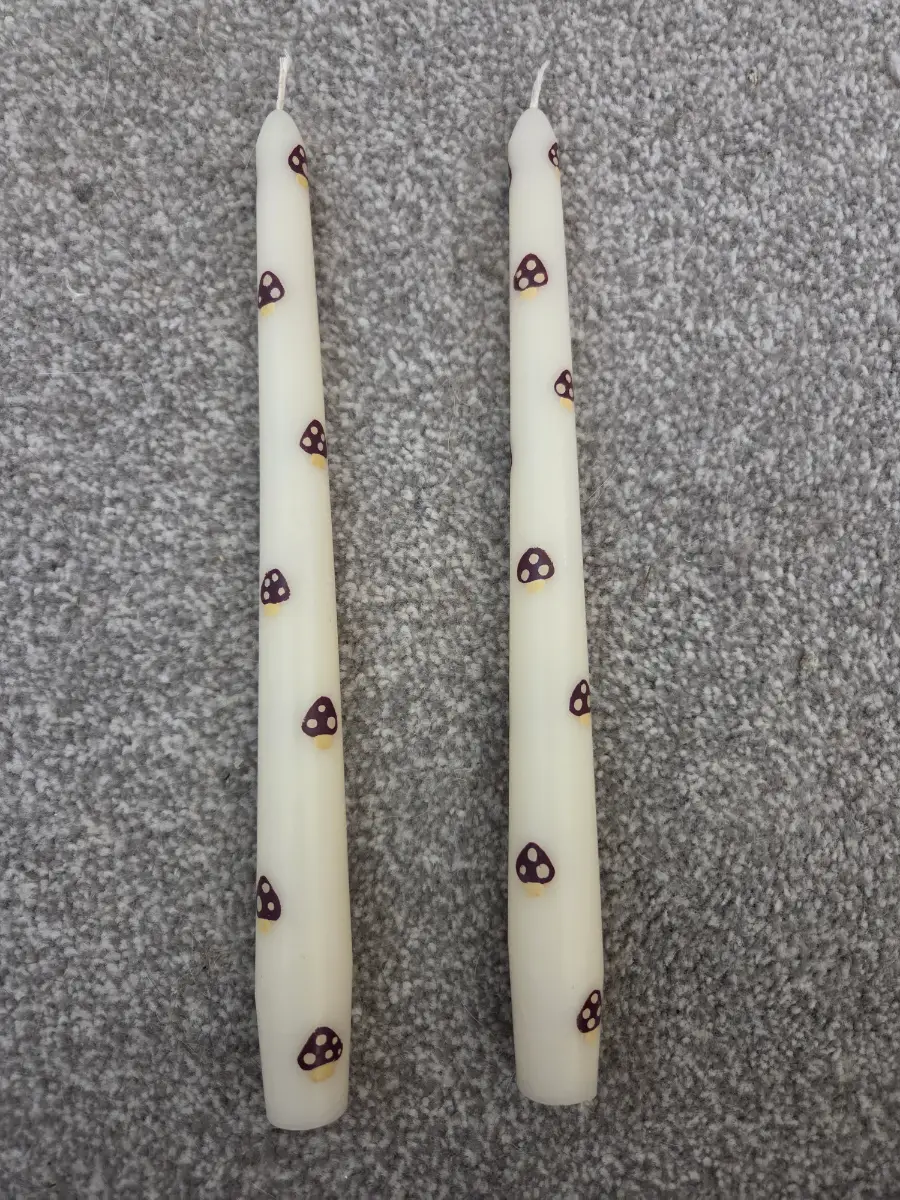 Cream taper candles with little brown mushrooms