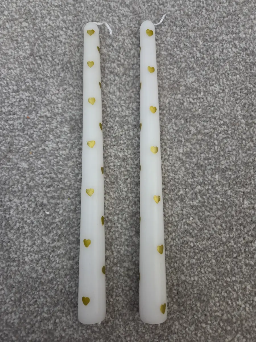 Golden hearts and white taper candles