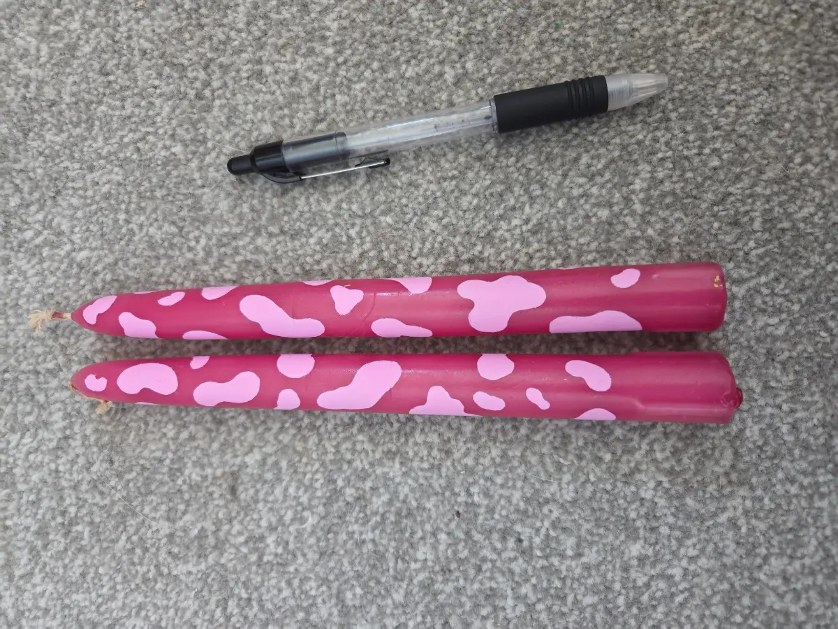 Bright pink taper candles with pink cow print